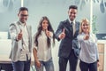 Happy business people showing thumbs up while standing in the office Royalty Free Stock Photo