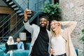 Happy business people, working in office. Smiling Caucasian lady and African man making joint selfie photo on smartphone Royalty Free Stock Photo