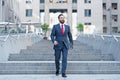 Happy business person walks downstairs in hurry movement with tablet. Young contemporary businessman walking in finance centre Royalty Free Stock Photo