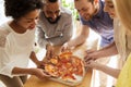 Happy business team eating pizza in office