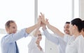 Happy business team giving high five in office Royalty Free Stock Photo