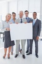 Happy business team holding large blank poster Royalty Free Stock Photo