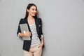 Happy business woman with arm in pocket holding laptop computer Royalty Free Stock Photo