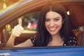 Happy business woman driving her car and showing thumb up.