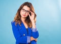 Happy business woman in eyeglasses looking at the camera over blue background Royalty Free Stock Photo