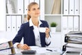 Happy business woman or female accountant having some minutes for coffee and pleasure at working place Royalty Free Stock Photo