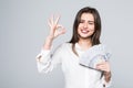 Happy business woman holding us dollar money and gesturing OK sign over white background Royalty Free Stock Photo