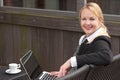 Happy business woman with laptop and cup of coffee outdoors Royalty Free Stock Photo