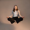 Happy business woman levitates in the lotus position and smiles, stress control at work,