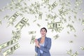 Happy business woman looking at money rain against white background