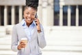 Happy business woman on a phone call and drinking coffee while outside in the city, happy and confident. Young Royalty Free Stock Photo