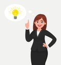Happy business woman pointing hand up and bright light bulb appearing in the thought bubble.