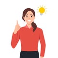 Happy business woman pointing hand up and bright light bulb appearing in the thought bubble. Idea and innovation concept Royalty Free Stock Photo