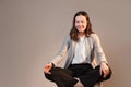 Happy business woman sitting in the lotus position and smiling, stress control at work,