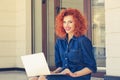 Happy business woman student smiling looking at you, sitting on block stairs with laptop computer on her knees. One single person Royalty Free Stock Photo