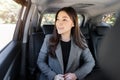 Happy business woman thinking and looking view out of window while sitting in the back seat of car Royalty Free Stock Photo