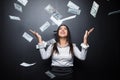 Happy business woman under a money rain made of dollars isolated on black