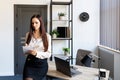 Happy business woman using pen and writing something in her notebook, raising her hand up, showing a greeting gesture Royalty Free Stock Photo