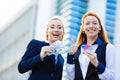 Happy business women holding credit cards and cash reward