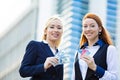 Happy business women holding credit cards and cash reward