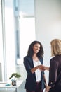 Happy business women shaking hands, meeting and greeting in an office. Confident young professional talking to a manager Royalty Free Stock Photo