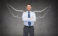 Happy businessman with angel wings over gray Royalty Free Stock Photo