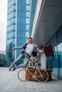Happy businessman with bicycle at office building