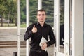 Happy businessman in black suit with digital tablet makes a gesture thumb up in the office. Royalty Free Stock Photo