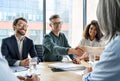 Happy businessman and businesswoman shaking hands at group meeting. Royalty Free Stock Photo