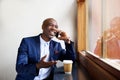 Happy businessman at a cafe talking on cell phone Royalty Free Stock Photo
