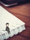 Happy businessman concept : Tiny cartoon man sit on note book Royalty Free Stock Photo