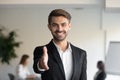 Happy businessman extending arm at camera for hand shake Royalty Free Stock Photo