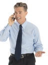 Happy Businessman Gesturing While Answering Smart Phone Royalty Free Stock Photo