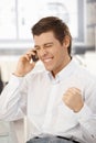 Happy businessman getting good news on phone