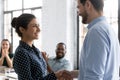 Happy businessman handshake biracial employee greeting with promotion