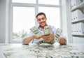 Happy businessman with heap of money in office Royalty Free Stock Photo