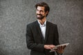 Happy businessman holding digital tablet outside of modern building Royalty Free Stock Photo