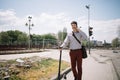 Happy businessman holding electric scooter and walking on sidewalk Royalty Free Stock Photo