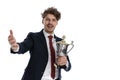 Happy businessman holding trophy, welcoming and celebrating Royalty Free Stock Photo