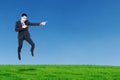 Happy businessman jumping and pointing something Royalty Free Stock Photo