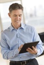 Happy Businessman Looking At Digital Tablet