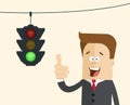 Happy businessman or manager in the background traffic light with a burning green. Royalty Free Stock Photo