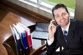 Happy businessman on mobile phone in office Royalty Free Stock Photo