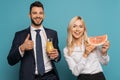 Happy businessman with orange juice showing thumb up near smiling businesswoman with hello summer inscription on
