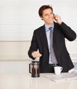 Happy businessman, phone call and coffee for discussion or communication in kitchen at home. Man or employee smile and