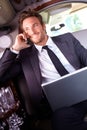 Happy businessman on phone call in limousine Royalty Free Stock Photo