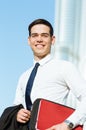 Happy businessman portrait with a modern city background.