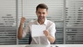 Happy businessman reading document, business letter, excited by good news