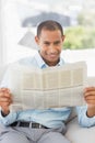 Happy businessman reading newspaper on the couch Royalty Free Stock Photo