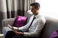 Happy businessman reading newspaper at hotel room Royalty Free Stock Photo